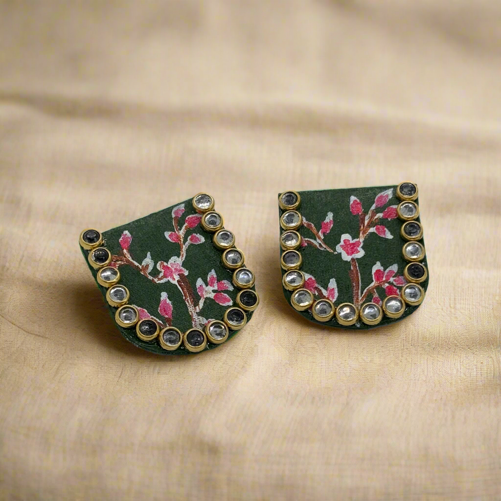 Pair of earrings with floral design and gemstone accents on a white background