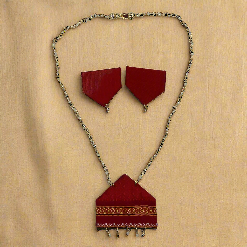 Red fabric jewelry set with gold chain on a white background