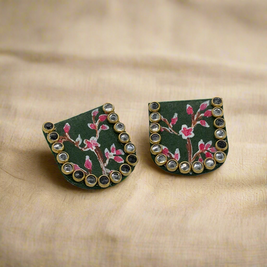 Pair of earrings with floral design and gemstone accents on a white background