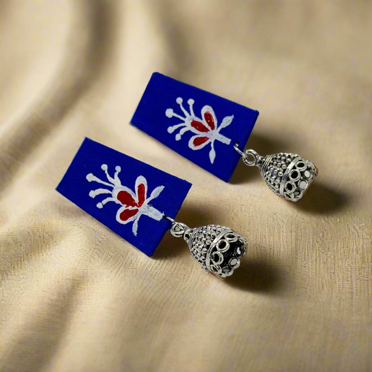 Pair of earrings with blue rectangular stones and silver heart-shaped pendants on a white background