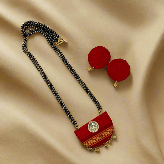 Red necklace with gold accents and red earrings on a white background