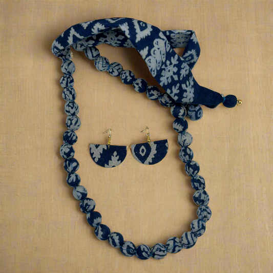 Jewelry set with necklace, earrings, and headband featuring blue and gray pattern on a white background