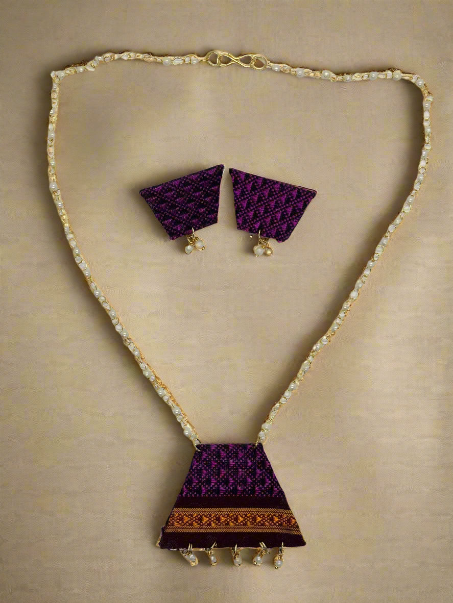 Jewelry set with purple fabric pendants on a gold chain against a white background