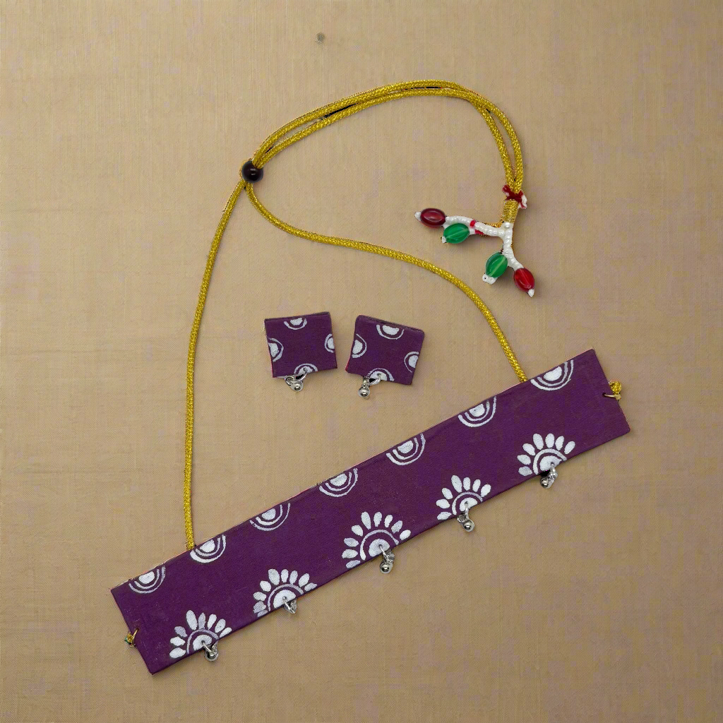 Jewelry set with purple fabric strip, yellow necklace, and earrings on a white background