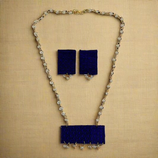Navy blue necklace and earrings set on a white background