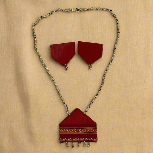 Red fabric jewelry set with gold chain on a white background