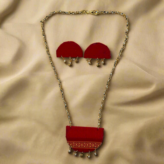 Red jewelry set with gold chain on a white background